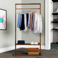A brown, Z-shaped pants rack made of iron and PVC, placed in a home environment with clothes hanging on it.