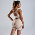 A female model wearing beige seamless knitted exercise yoga clothes, consisting of a top and pants, posing from the back.